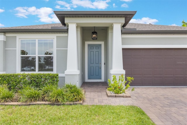 1740 Standing Rock Cir, Oakland, FL 34787 - property entrance with roof with shingles, stucco siding, a garage, and driveway