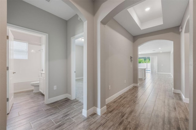 1740 Standing Rock Cir, Oakland, FL 34787 - corridor featuring wood finished floors, arched walkways, recessed lighting, and a tray ceiling