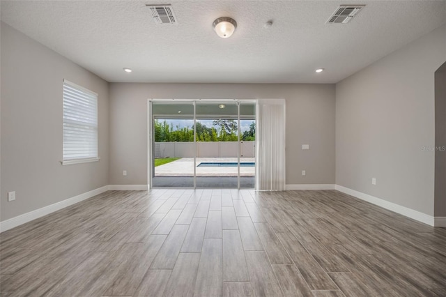 1740 Standing Rock Cir, Oakland, FL 34787 - spare room featuring wood finished floors, recessed lighting, and a textured ceiling