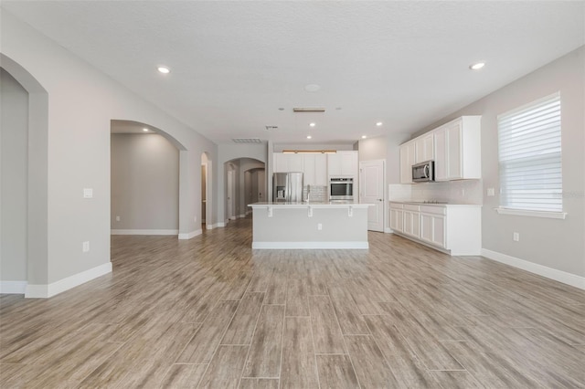 1740 Standing Rock Cir, Oakland, FL 34787 - unfurnished living room featuring light wood-type flooring, arched walkways, and recessed lighting