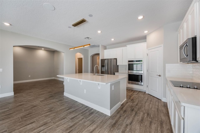 1740 Standing Rock Cir, Oakland, FL 34787 - kitchen featuring stainless steel appliances, arched walkways, dark wood-style flooring, backsplash, and recessed lighting
