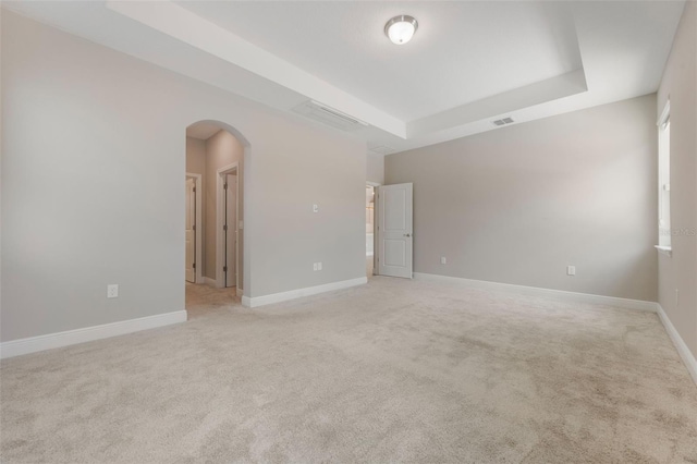 1740 Standing Rock Cir, Oakland, FL 34787 - empty room with a tray ceiling, arched walkways, and light colored carpet