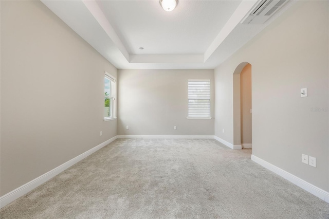1740 Standing Rock Cir, Oakland, FL 34787 - empty room with arched walkways, a tray ceiling, and light colored carpet