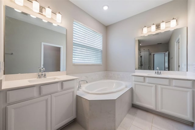 1740 Standing Rock Cir, Oakland, FL 34787 - bathroom featuring two vanities, a garden tub, a shower stall, and tile patterned floors