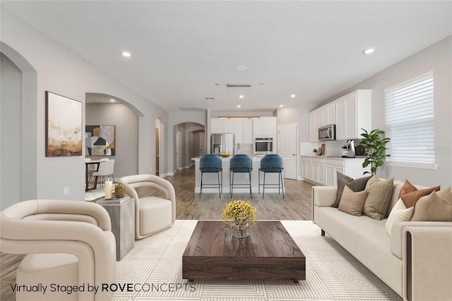 1740 Standing Rock Cir, Oakland, FL 34787 - living area featuring arched walkways, light wood-type flooring, and recessed lighting