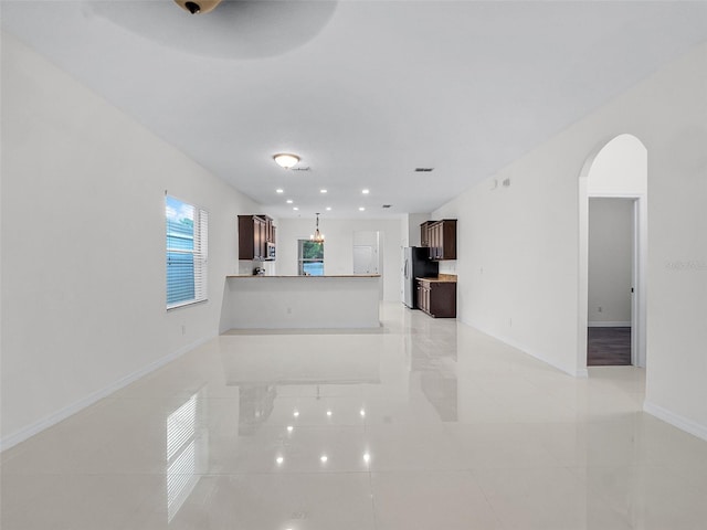 15647 Braintree Ln, Winter Garden, FL 34787 - unfurnished living room with arched walkways, light tile patterned flooring, and recessed lighting