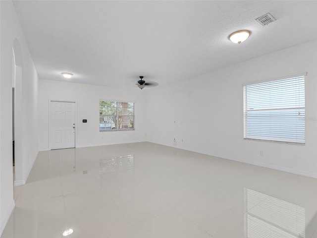 15647 Braintree Ln, Winter Garden, FL 34787 - spare room featuring a ceiling fan, arched walkways, tile patterned floors, and a textured ceiling