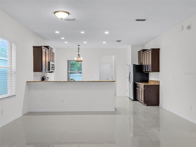 15647 Braintree Ln, Winter Garden, FL 34787 - kitchen with dark brown cabinets, a chandelier, hanging light fixtures, light countertops, and appliances with stainless steel finishes