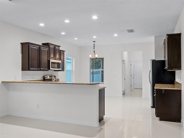15647 Braintree Ln, Winter Garden, FL 34787 - kitchen featuring stainless steel appliances, dark brown cabinetry, a chandelier, recessed lighting, and light stone counters