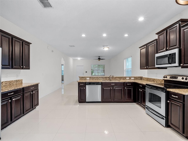 15647 Braintree Ln, Winter Garden, FL 34787 - kitchen with stainless steel appliances, arched walkways, ceiling fan, recessed lighting, and light stone counters