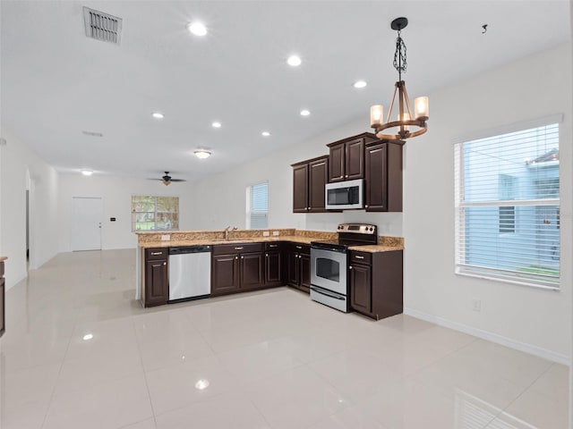 15647 Braintree Ln, Winter Garden, FL 34787 - kitchen with appliances with stainless steel finishes, a chandelier, dark brown cabinetry, decorative light fixtures, and a peninsula