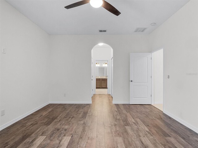 15647 Braintree Ln, Winter Garden, FL 34787 - spare room with arched walkways, a ceiling fan, and wood finished floors