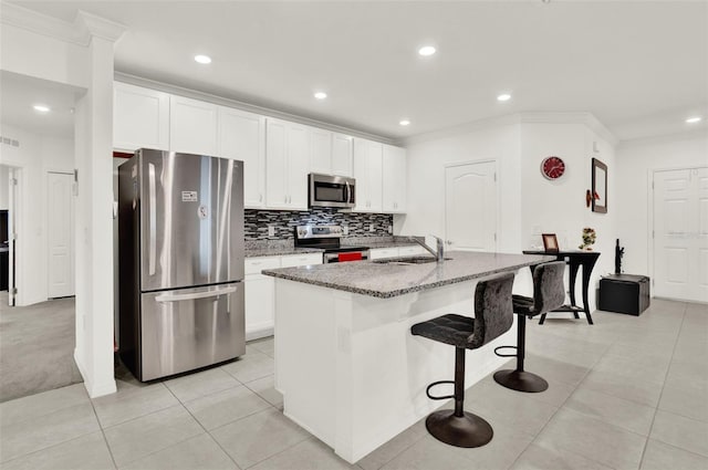 804 Glen Creek Ct, Fruitland Park, FL 34731 - kitchen featuring appliances with stainless steel finishes, crown molding, a sink, a center island with sink, and light stone countertops