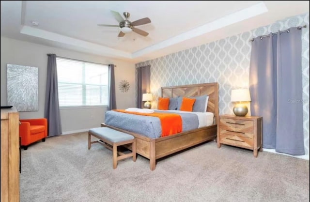 1625 Nassau Point Trl, Kissimmee, FL 34747 - carpeted bedroom featuring a tray ceiling and a ceiling fan
