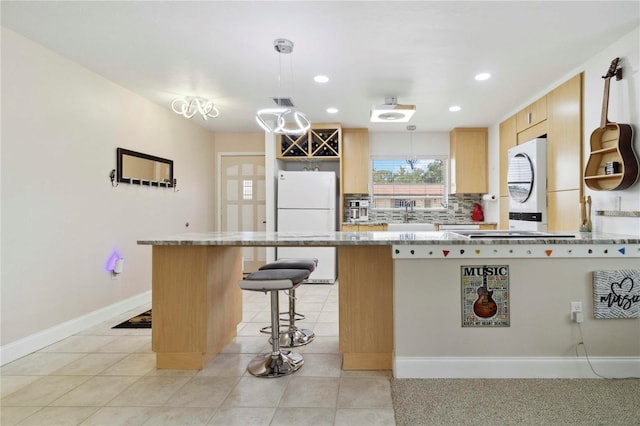 4549 Tippecanoe Trl Unit 20, Sarasota, FL 34233 - kitchen featuring freestanding refrigerator, a peninsula, a kitchen bar, recessed lighting, and a sink