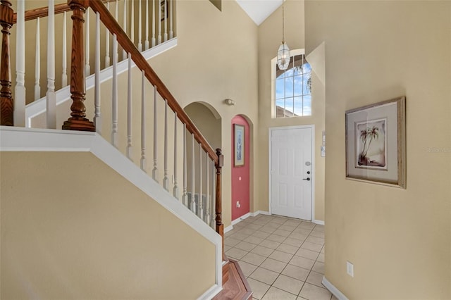 8113 Sun Palm Dr, Kissimmee, FL 34747 - entrance foyer with high vaulted ceiling, tile patterned floors, stairway, arched walkways, and baseboards