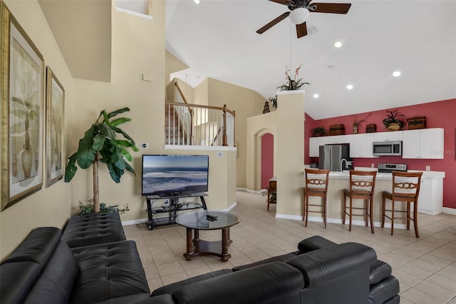 8113 Sun Palm Dr, Kissimmee, FL 34747 - living room with ceiling fan, light tile patterned floors, arched walkways, high vaulted ceiling, and baseboards