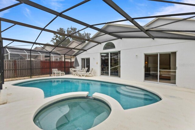 3018 Bransbury Ct, Kissimmee, FL 34747 - view of swimming pool featuring a pool with connected hot tub, a patio, and glass enclosure