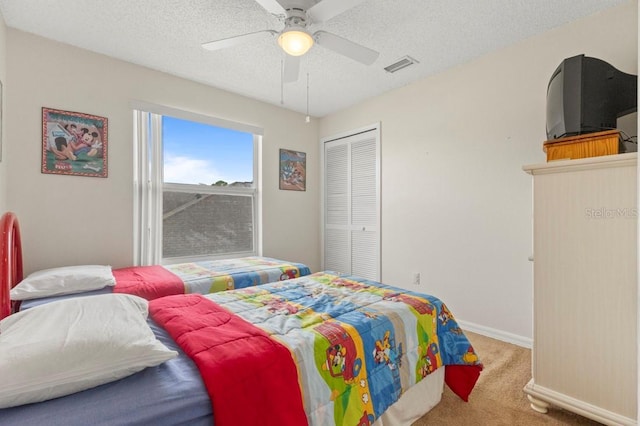 3018 Bransbury Ct, Kissimmee, FL 34747 - carpeted bedroom featuring a closet, a textured ceiling, baseboards, and a ceiling fan