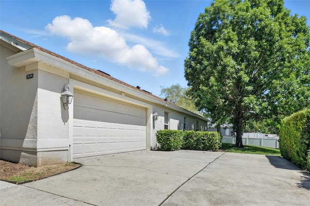 2674 Spicebush Loop, Apopka, FL 32712 - view of side of property featuring concrete driveway, stucco siding, and an attached garage