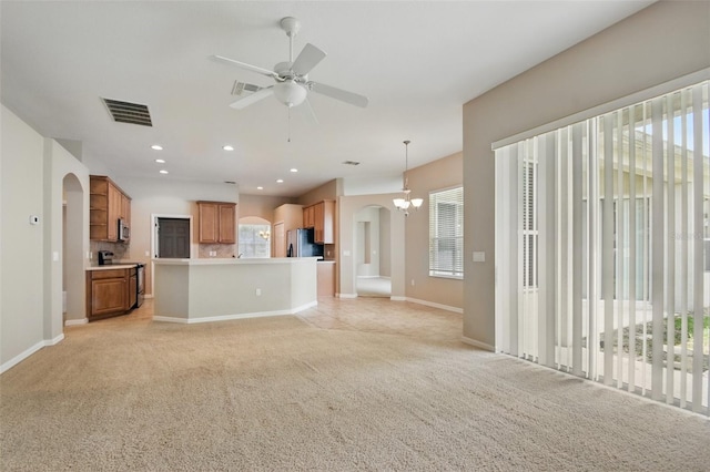 2674 Spicebush Loop, Apopka, FL 32712 - unfurnished living room with arched walkways, light colored carpet, a ceiling fan, baseboards, and recessed lighting