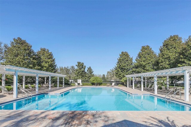 2674 Spicebush Loop, Apopka, FL 32712 - community pool with a pergola, view of wooded area, and a patio