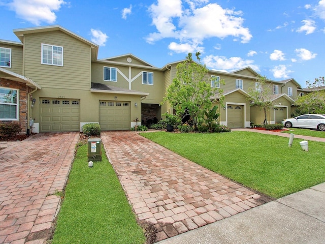 2311 Chatham Place Dr, Orlando, FL 32824 - multi unit property with stucco siding, driveway, an attached garage, and a front lawn