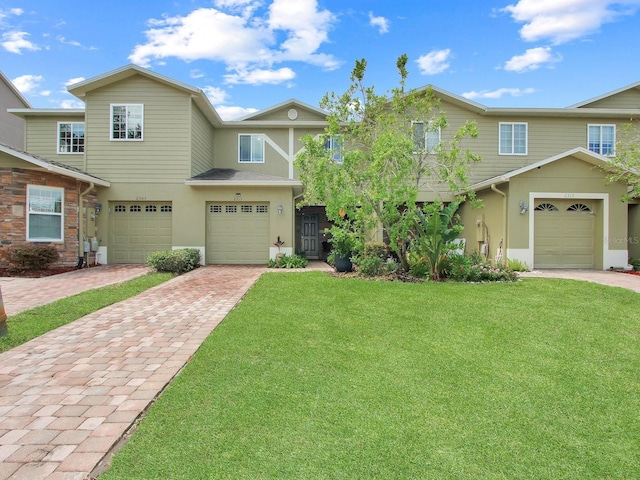 2311 Chatham Place Dr, Orlando, FL 32824 - townhome / multi-family property with driveway, stucco siding, a front yard, and a garage