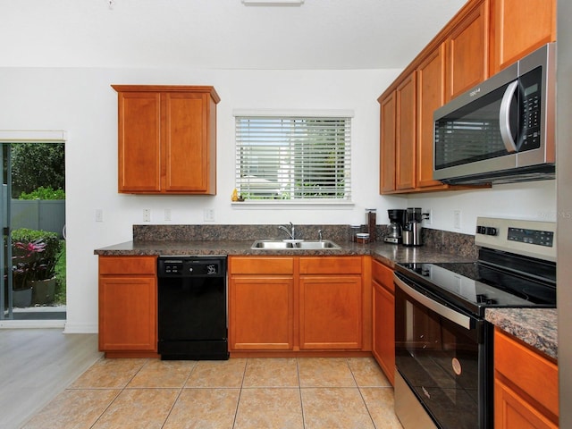 2311 Chatham Place Dr, Orlando, FL 32824 - kitchen with appliances with stainless steel finishes, a sink, brown cabinets, and light tile patterned floors