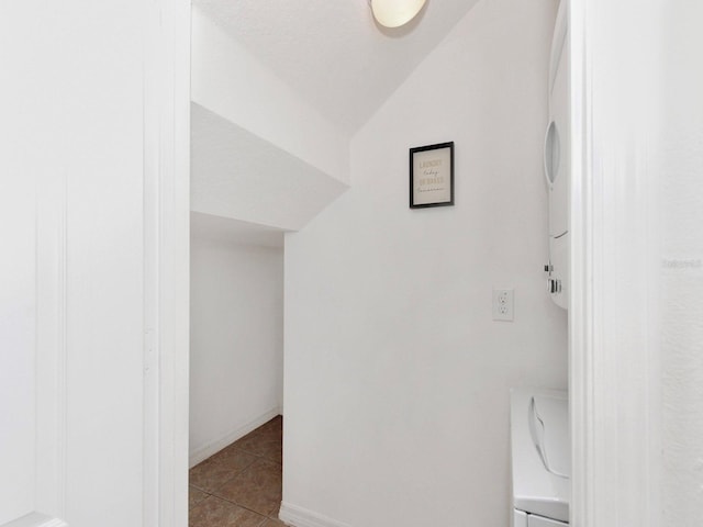 2311 Chatham Place Dr, Orlando, FL 32824 - hallway with tile patterned floors, estacked washer and dryer, lofted ceiling, and baseboards