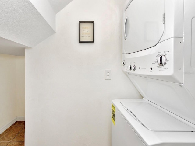 2311 Chatham Place Dr, Orlando, FL 32824 - laundry area featuring stacked washer / drying machine, tile patterned floors, and baseboards