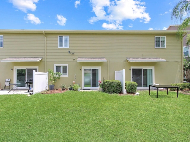 2311 Chatham Place Dr, Orlando, FL 32824 - rear view of property with a lawn, stucco siding, and a patio area