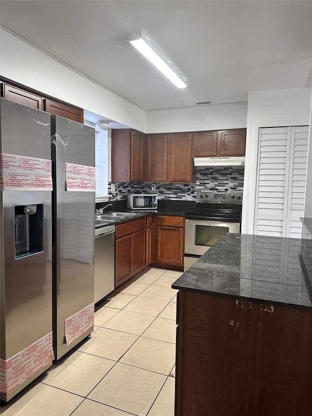3057 Aaron Burr Ave Unit 2, Winter Park, FL 32792 - kitchen with stainless steel appliances, under cabinet range hood, light tile patterned floors, backsplash, and a sink