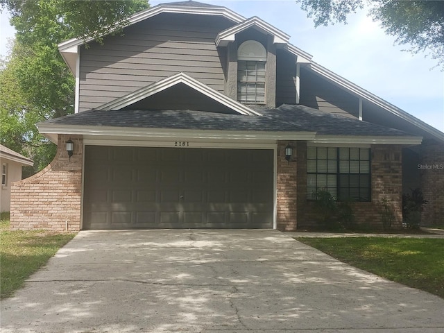 2181 Wekiwa Oaks Dr, Apopka, FL 32703 - view of front facade with concrete driveway, a garage, and brick siding