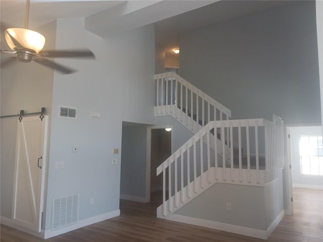 2181 Wekiwa Oaks Dr, Apopka, FL 32703 - stairway featuring wood finished floors, a ceiling fan, baseboards, and a towering ceiling