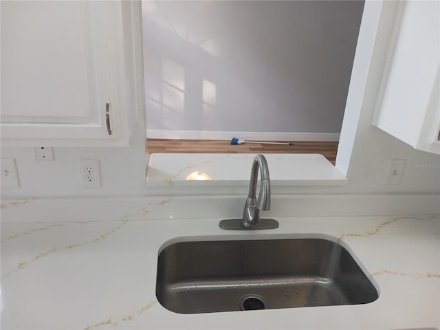 2181 Wekiwa Oaks Dr, Apopka, FL 32703 - kitchen view of a sink, white cabinets, and light stone counters