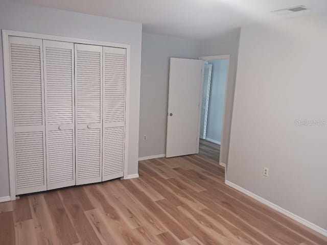 2181 Wekiwa Oaks Dr, Apopka, FL 32703 - unfurnished bedroom with a closet, baseboards, and light wood-type flooring
