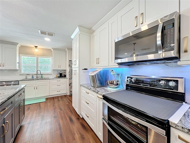 404 Broadview Ave, Altamonte Springs, FL 32701 - kitchen with appliances with stainless steel finishes, a sink, dark wood-type flooring, white cabinets, and light stone counters