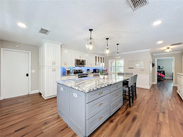 404 Broadview Ave, Altamonte Springs, FL 32701 - kitchen featuring appliances with stainless steel finishes, white cabinets, crown molding, dark wood finished floors, and baseboards