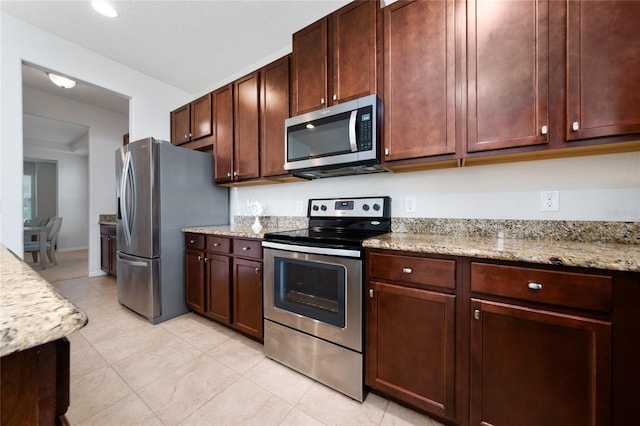 4952 Longmeadow Park St, Orlando, FL 32811 - kitchen with stainless steel appliances, light stone counters, and light tile patterned floors
