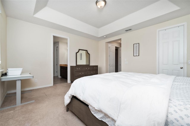 4952 Longmeadow Park St, Orlando, FL 32811 - bedroom featuring a tray ceiling, light carpet, baseboards, and connected bathroom