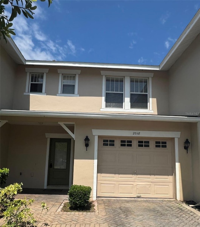2018 Cypress Bay Blvd, Kissimmee, FL 34743 - doorway to property featuring stucco siding, a garage, and decorative driveway