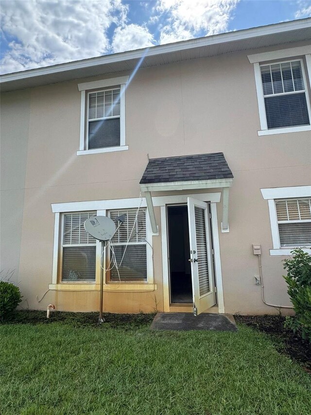 2018 Cypress Bay Blvd, Kissimmee, FL 34743 - rear view of house with stucco siding and a yard