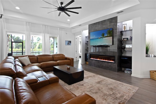 95353 Orchid Blossom Trl, Fernandina Beach, FL 32034 - living area with a ceiling fan, a tray ceiling, wood finished floors, a tiled fireplace, and recessed lighting