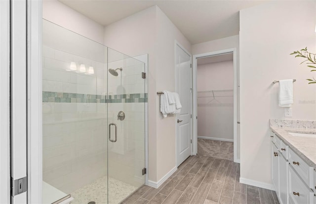 1811 Spring Shower Cir, Kissimmee, FL 34744 - full bath with wood finish floors, a shower stall, vanity, baseboards, and a spacious closet