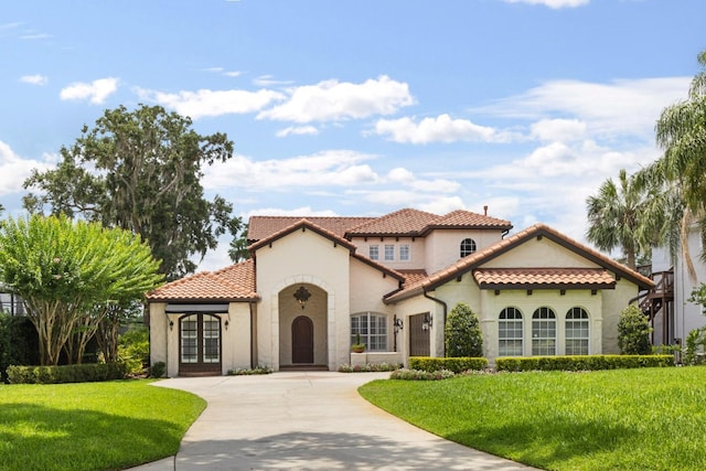 11018 Lake Butler Blvd, Windermere, FL 34786 - mediterranean / spanish house with french doors, stucco siding, a front lawn, a tiled roof, and concrete driveway