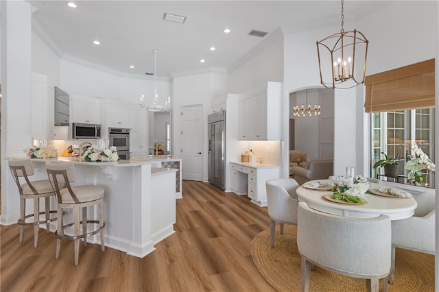11018 Lake Butler Blvd, Windermere, FL 34786 - kitchen featuring a chandelier, appliances with stainless steel finishes, a peninsula, a high ceiling, and ornamental molding