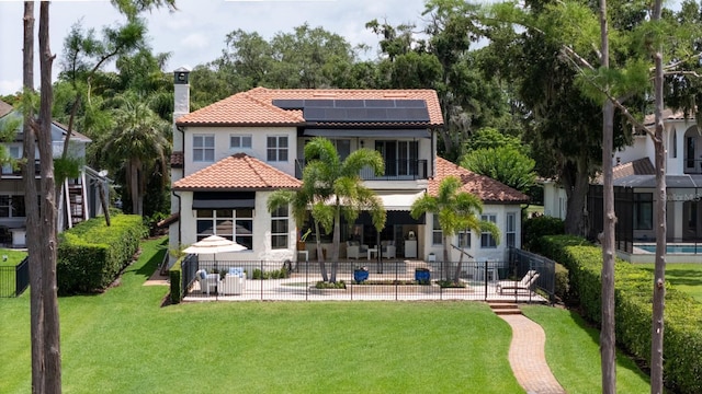 11018 Lake Butler Blvd, Windermere, FL 34786 - back of house featuring a patio, roof mounted solar panels, a chimney, a tiled roof, and stucco siding