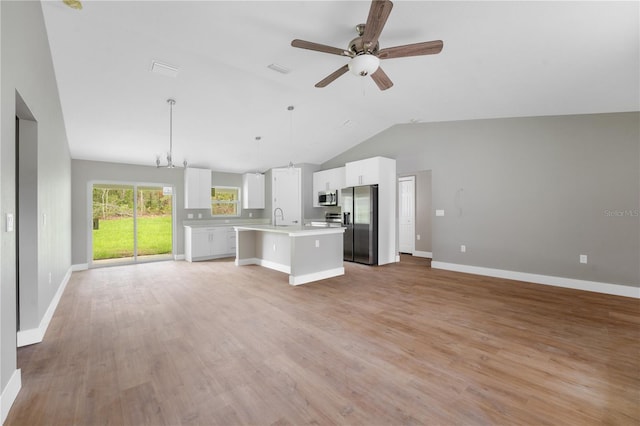 9299 N Tahiti Way, Citrus Springs, FL 34433 - unfurnished living room featuring a sink, lofted ceiling, ceiling fan, light wood-type flooring, and baseboards