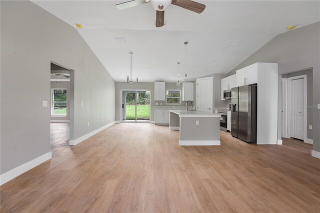 9299 N Tahiti Way, Citrus Springs, FL 34433 - kitchen with stainless steel appliances, lofted ceiling, light countertops, open floor plan, and white cabinetry